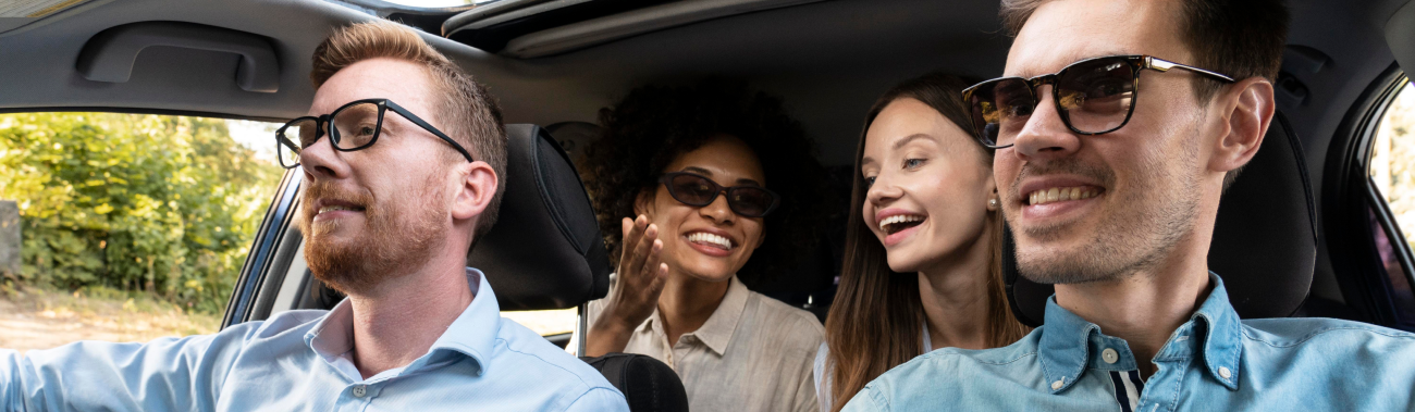 Happy passengers and driver in a car representing RIDEN ride-sharing service